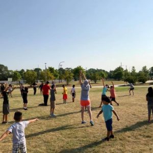 ICE Program mentors with group of kids exercising in field
